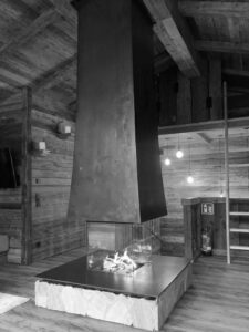schwarz weißes Bild von dunklerm Kaminofen von Mandl & Bauer in moderner Holzhütte