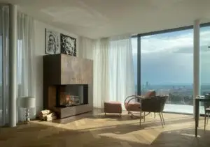 Kaminofen von Mandl & Bauer in minimalistischem Raum mit Glasfensterfront mit Aussicht